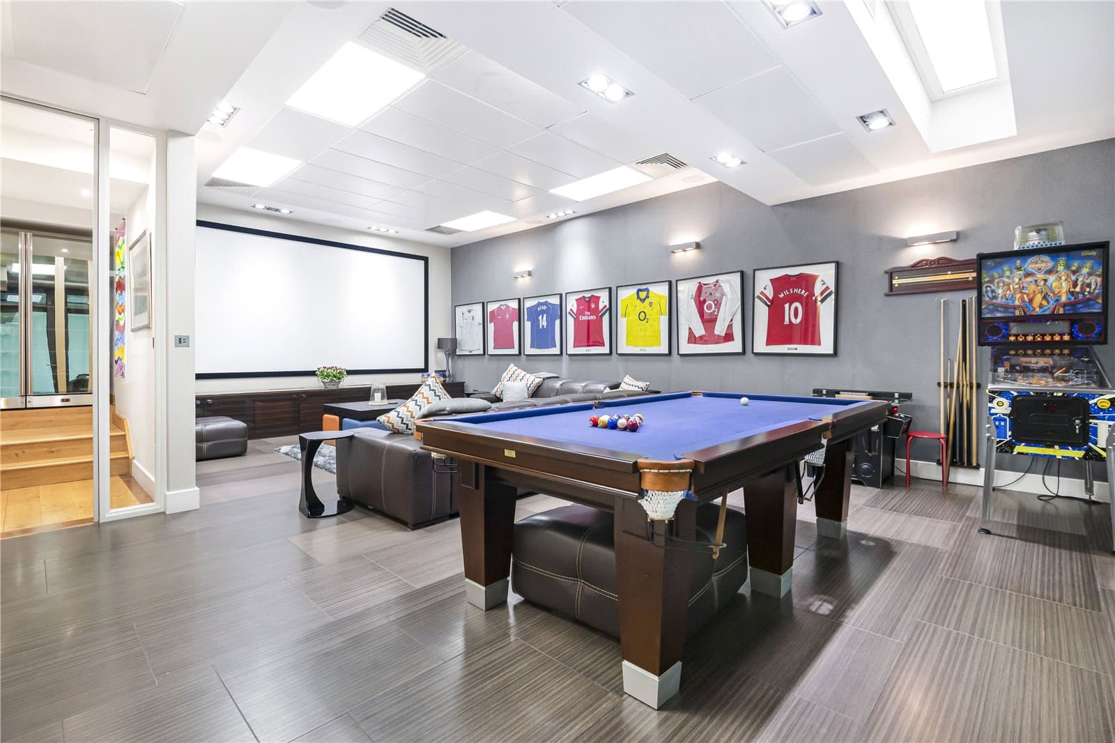 Lower ground entertainment room with cinema screen, pool table and lounge seating.