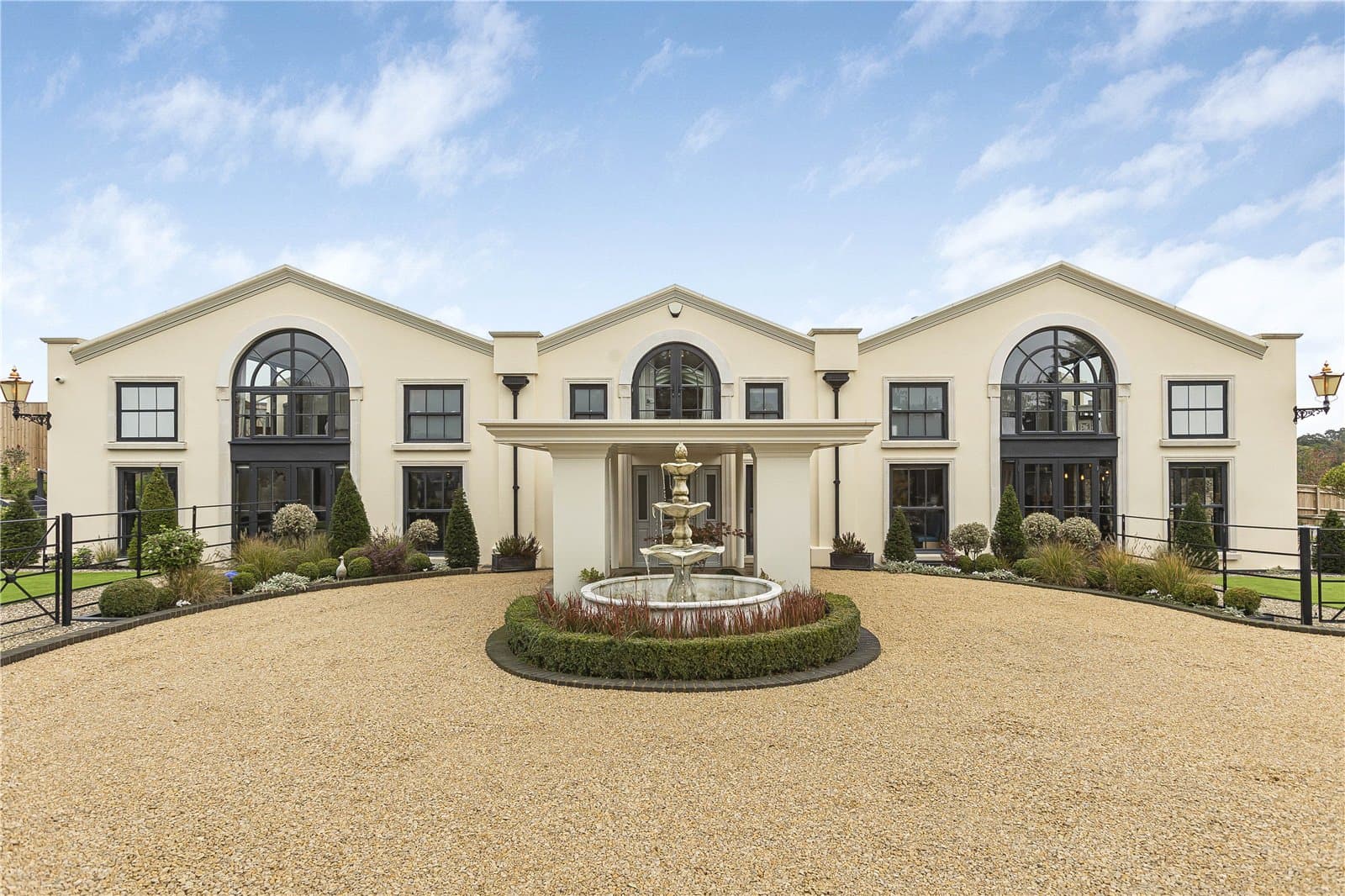 Symmetrical detached residence in Theobalds Park with arched windows, central portico entrance, landscaped forecourt and fountain
