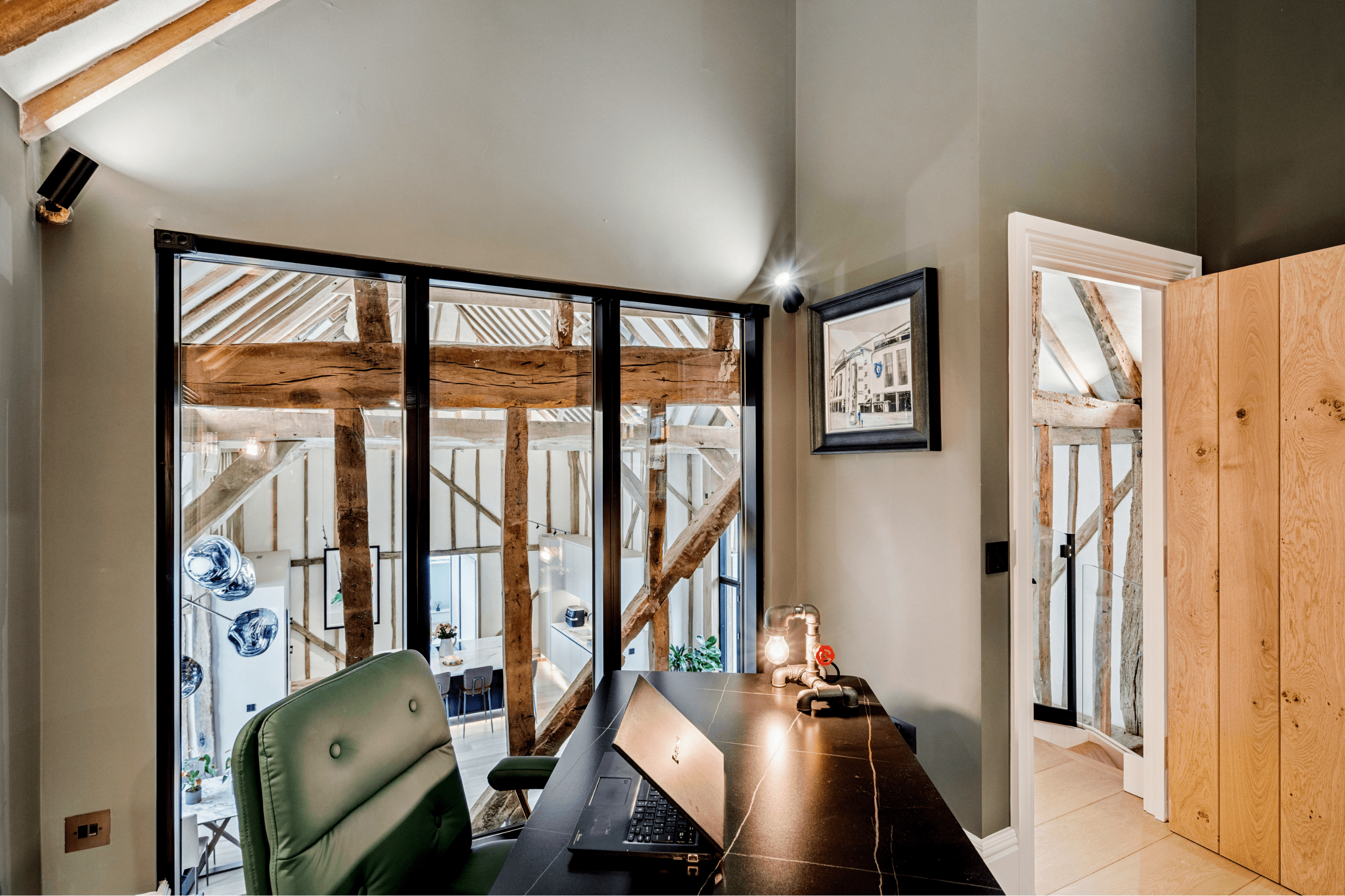Elevated study area overlooking the Great Room with exposed timber beams and workspace desk.