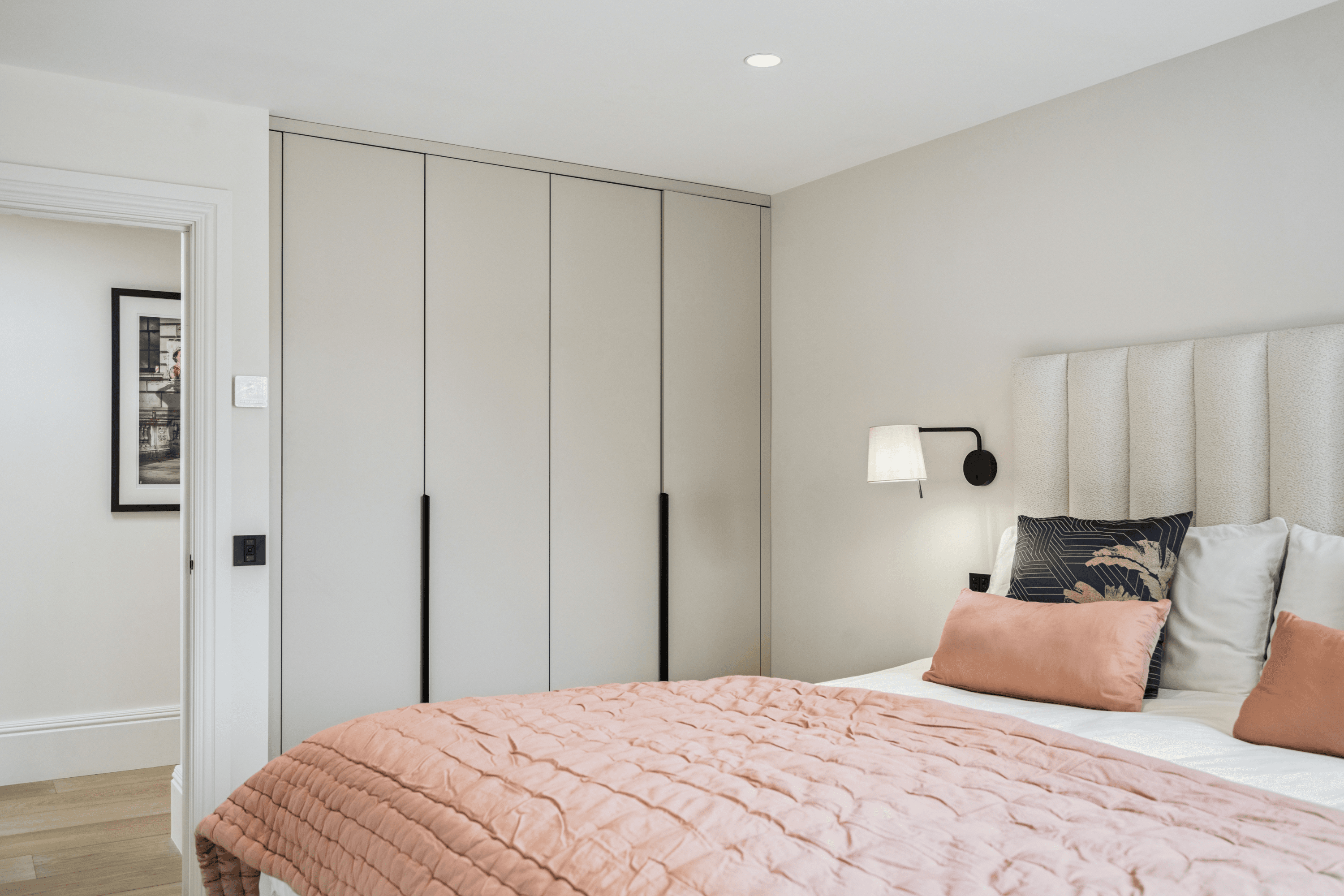 Guest bedroom with built-in wardrobes and soft neutral interior within the barn conversion.