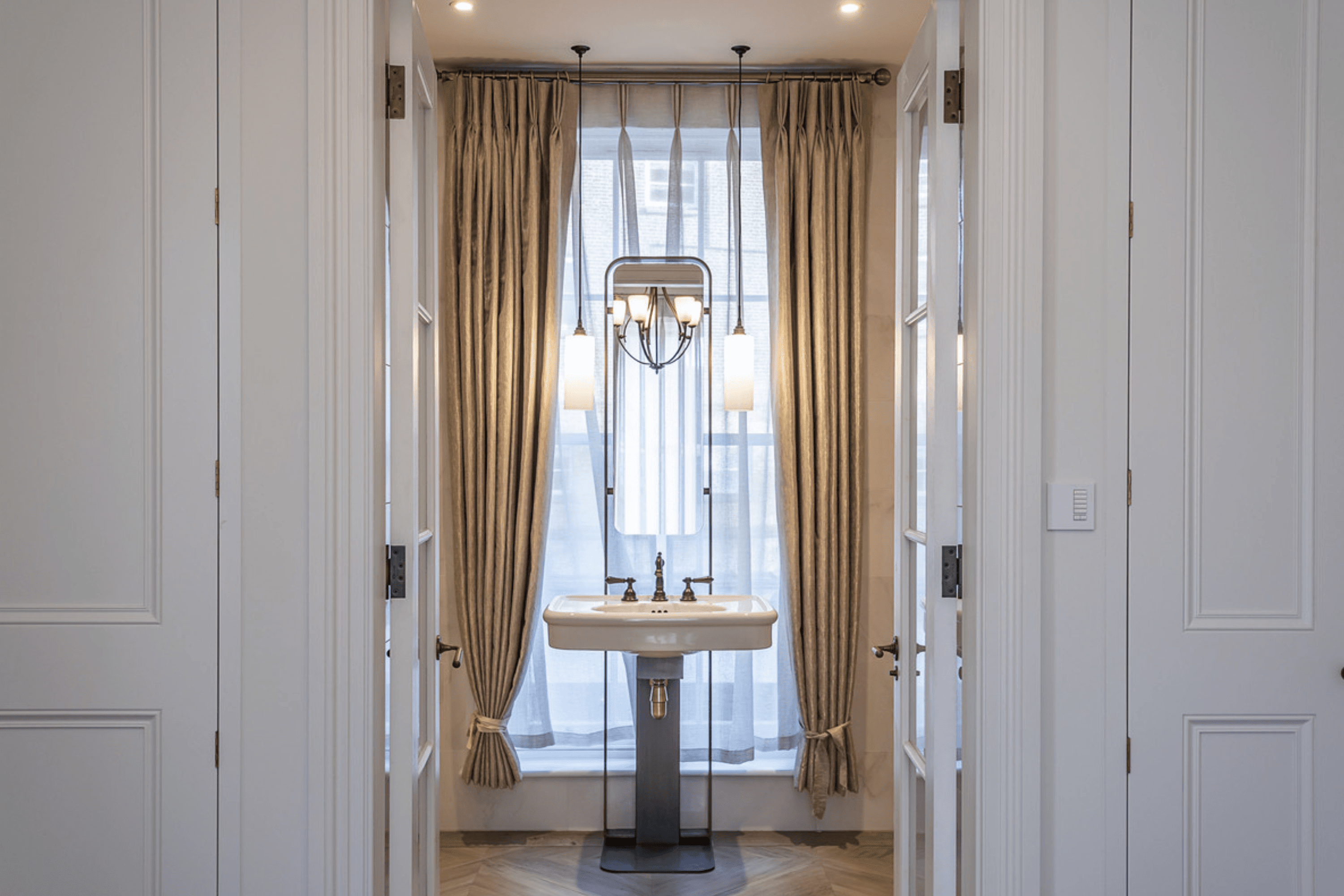 Marble bathroom with freestanding bath, walk in shower and twin basin vanity against textured wall finish.