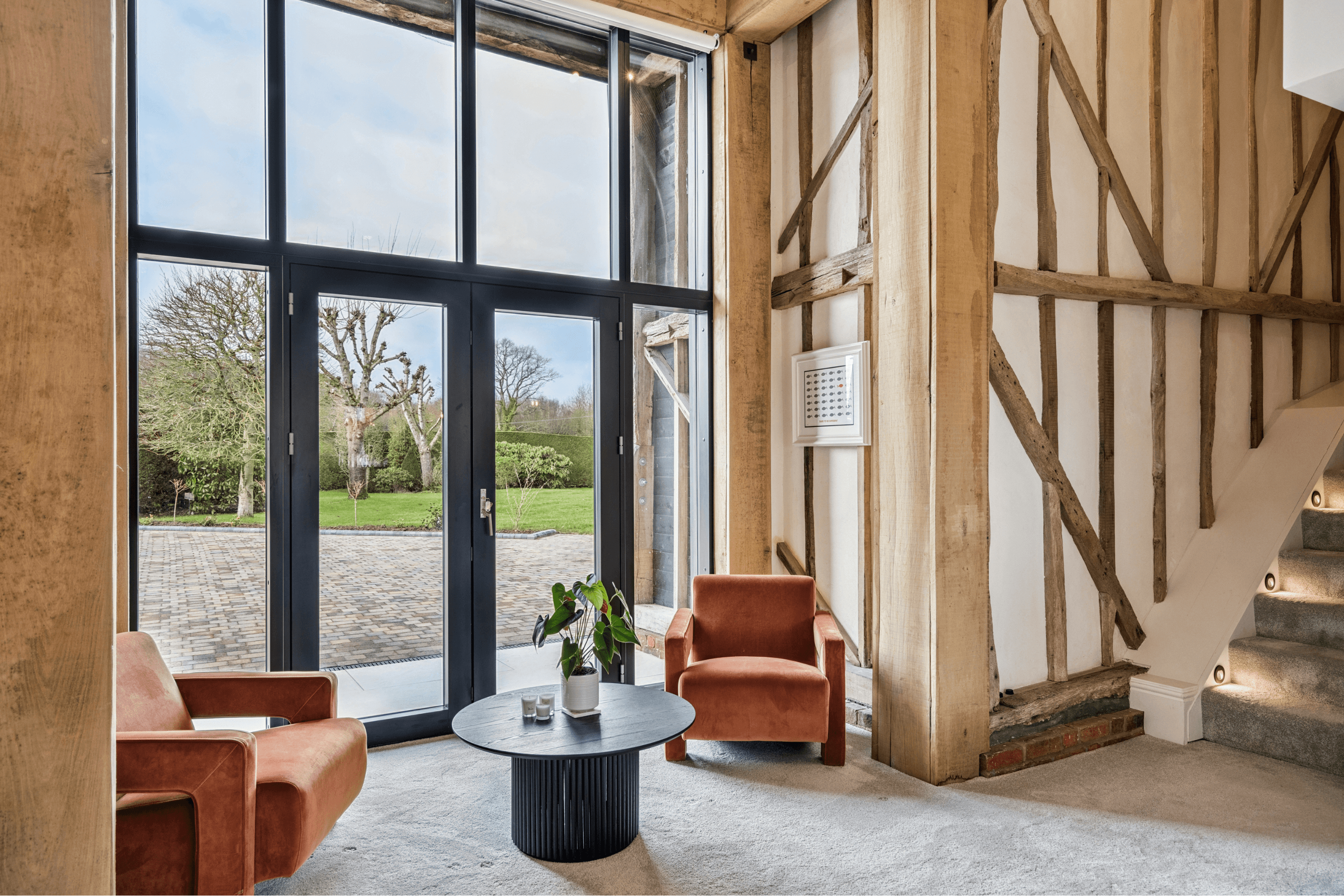 Relaxed seating area beside large glazed doors opening onto the gardens of the barn conversion.