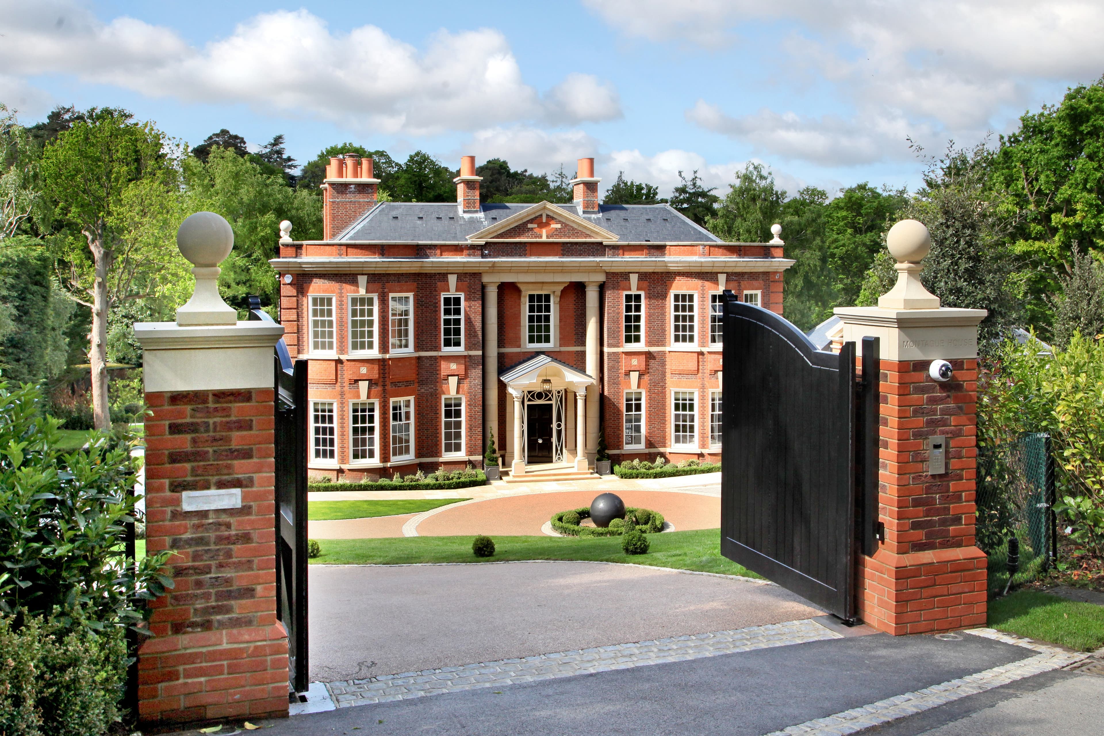 Gated red brick detached house on Linden Road St George's Hill Surrey with circular driveway and landscaped front garden